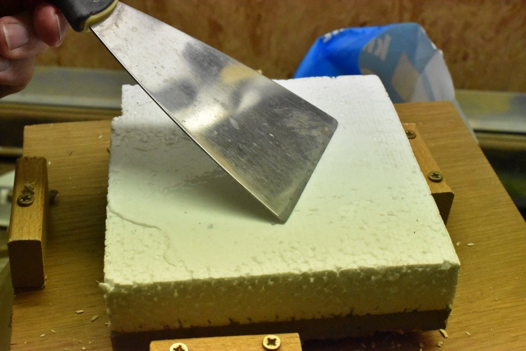 Leim wird mit Spachtel auf Unterseite und an den Seiten aufgetragen.